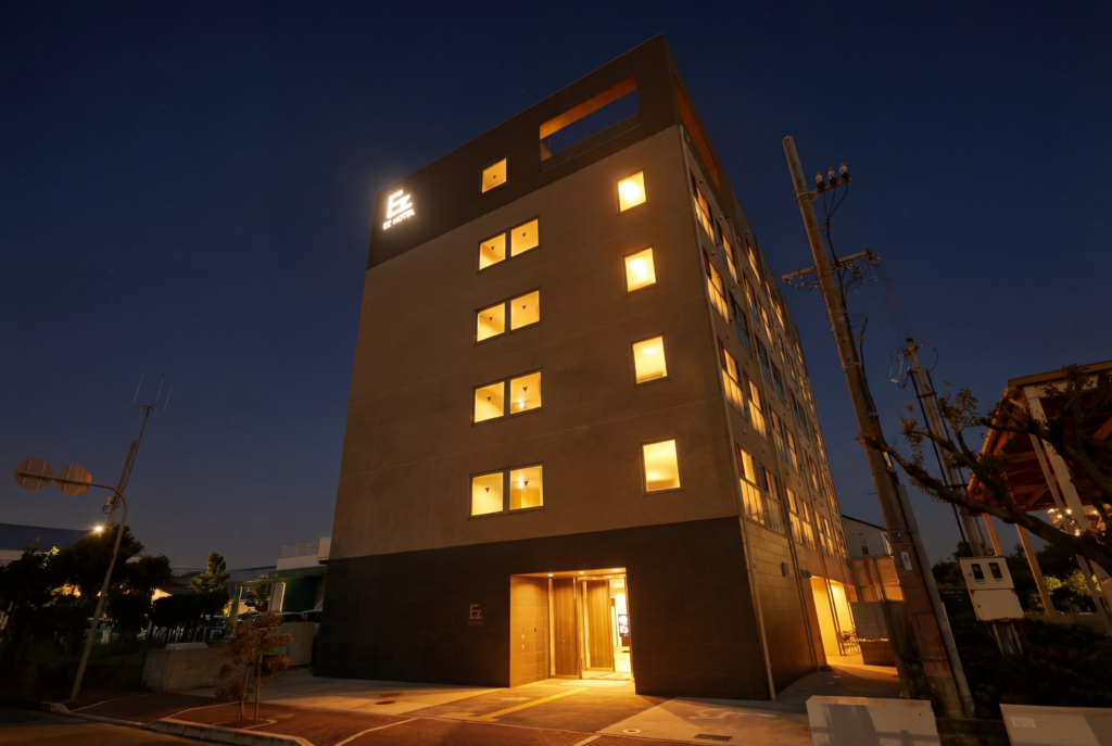 夜のEZ HOTEL 関西空港 Seasideの外観。客室の窓と1階の入口に明かりがともっている